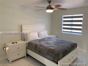 16121 Southwest 141st Avenue Miami, FL 33177 - Photo 3 of 11 a bedroom with a bed and a chandelier
