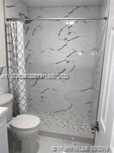 a bathroom with a toilet and a shower