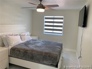 16121 Southwest 141st Avenue Miami, FL 33177 - Photo 10 of 11 a bedroom with a bed tv and a window