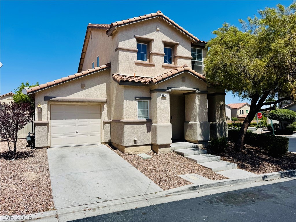 This two-story home presents a classic stucco exterior with a tiled roof.