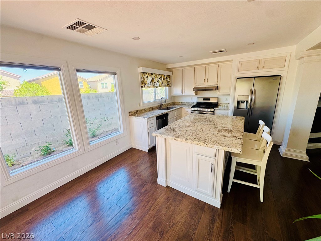 8920 Argus Reed Avenue Las Vegas, NV 89148 - Photo 3 of 10 This bright kitchen features an eat-in island, ample counter space, and rich hardwood flooring.