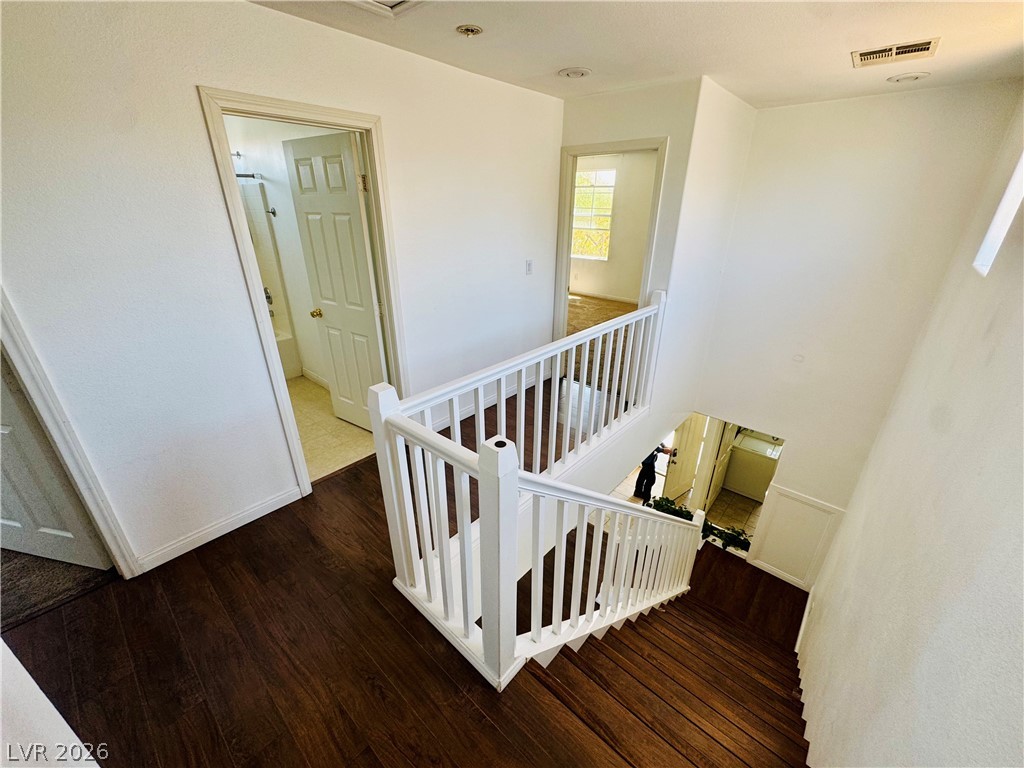 8920 Argus Reed Avenue Las Vegas, NV 89148 - Photo 6 of 10 This interior staircase features rich wood flooring, leading to a well-lit upper landing.