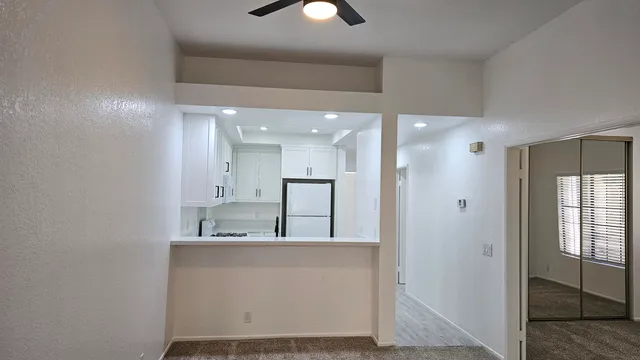 a kitchen with white cabinets and white appliances