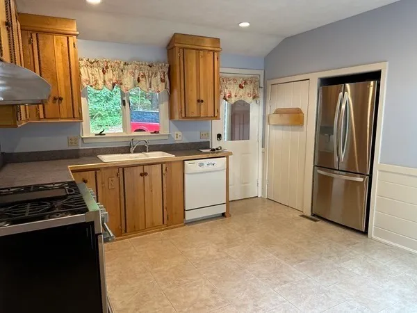 an empty room with wooden floor fireplace and windows