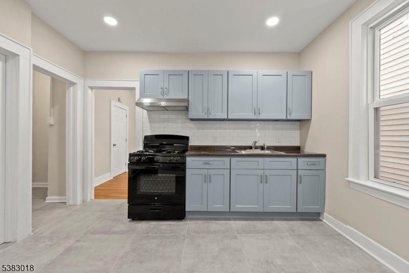 431 South 14th Street Newark, NJ 07103 - Photo 10 of 16 a kitchen with granite countertop a stove top oven sink and cabinets