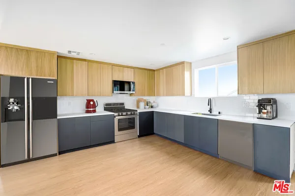 a kitchen with stainless steel appliances kitchen island granite countertop a refrigerator a sink dishwasher and a stove