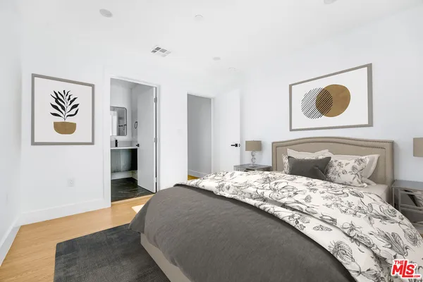a bedroom with a bed and painting on the wall