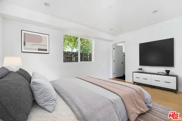 a bedroom with a bed and a flat screen tv
