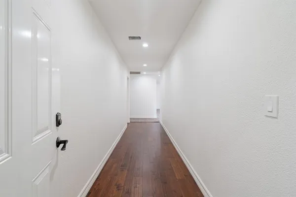 a view of a hallway with wooden floor