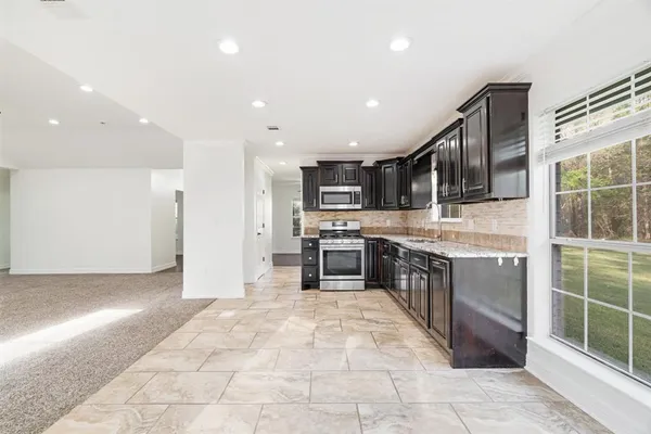 a large kitchen with stainless steel appliances lots of counter top space