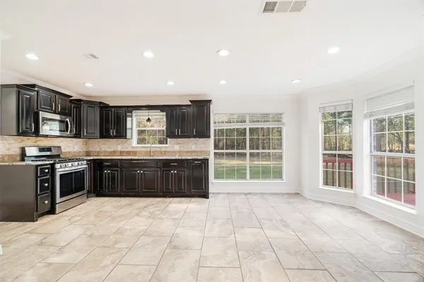 a large kitchen with stainless steel appliances and a stove top oven