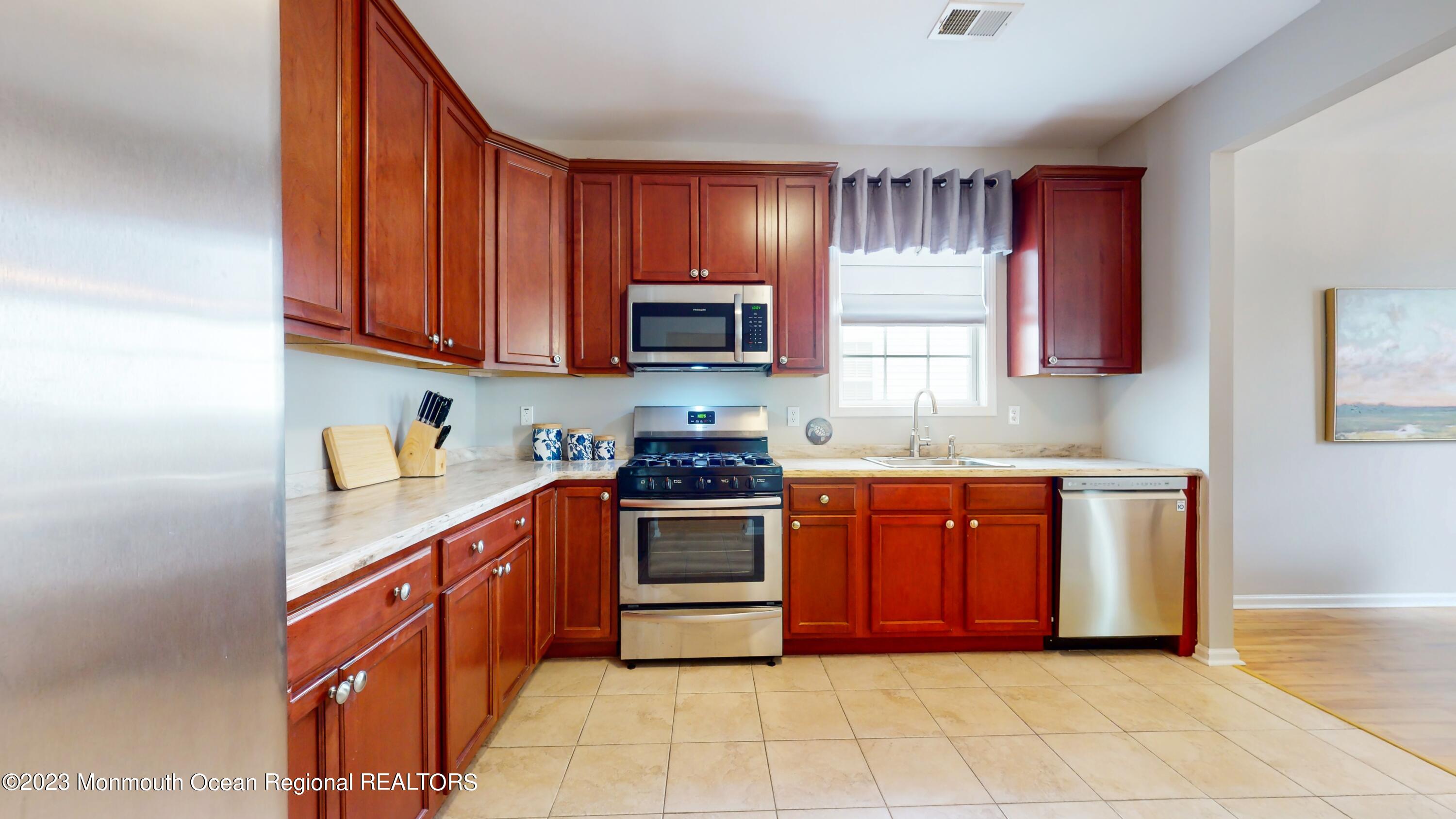 8 Silver Maple Lane Howell, NJ 07731 - Photo 10 of 27 a kitchen with stainless steel appliances granite countertop wooden cabinets a stove top oven a sink and dishwasher