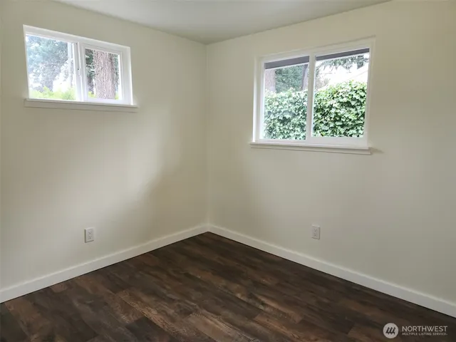 a view of a room with wooden floor and window