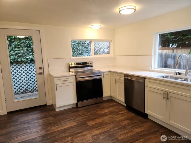 a kitchen with a stove a sink and a microwave