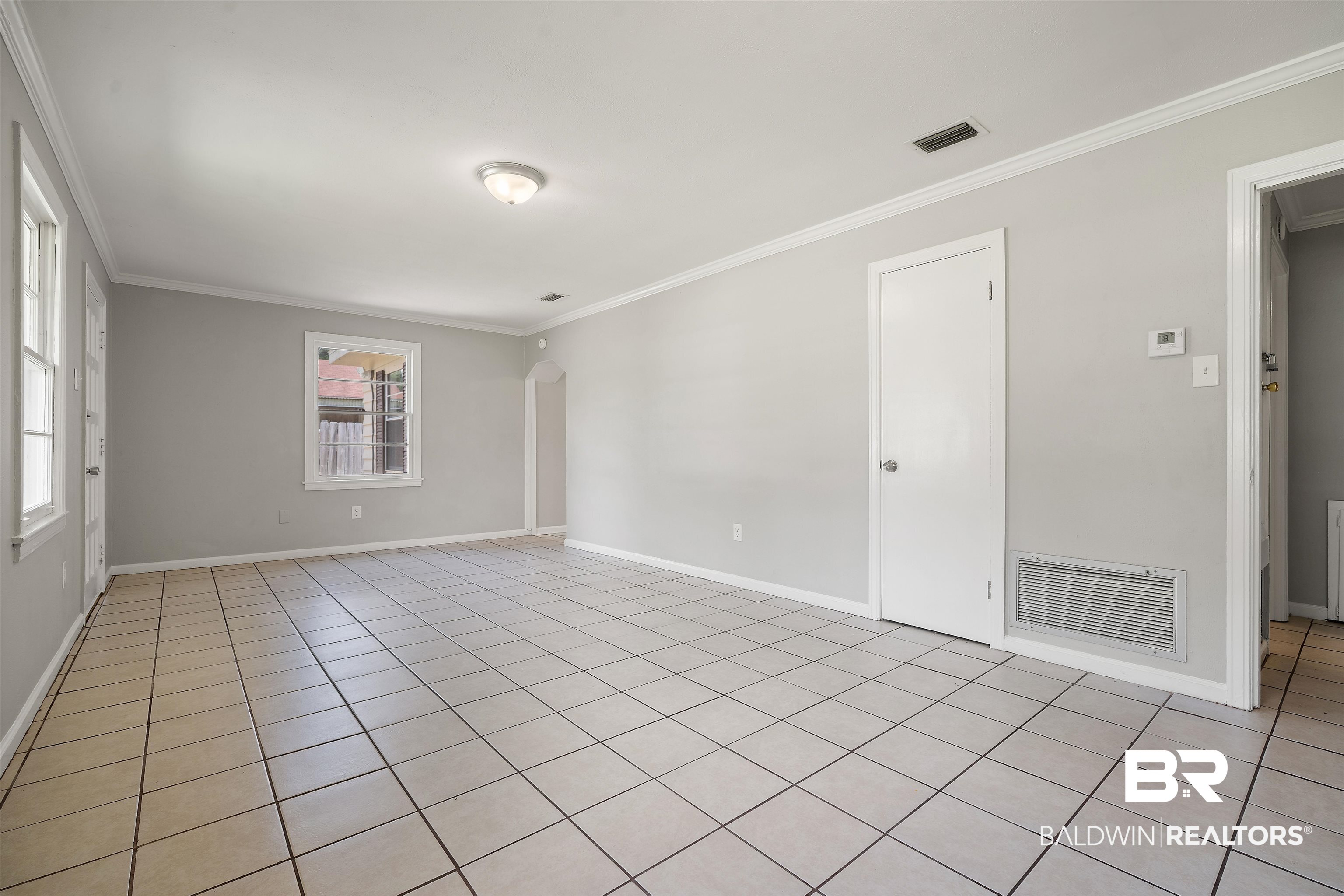 963 Shady Brook Drive Mobile, AL 36606 - Photo 6 of 20 Spare room with crown molding, light tile patterned flooring, arched walkways, and baseboards
