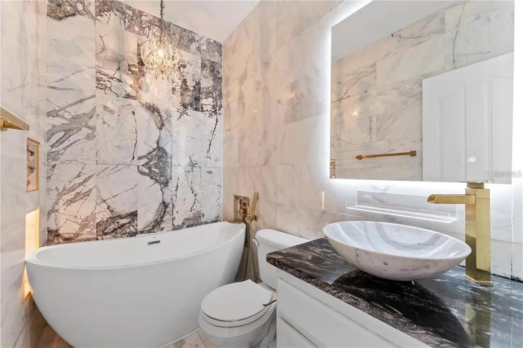 1437 Harbour Walk Road Tampa, FL 33602 - Photo 28 of 32 a bathroom with a granite countertop toilet a sink and a bathtub