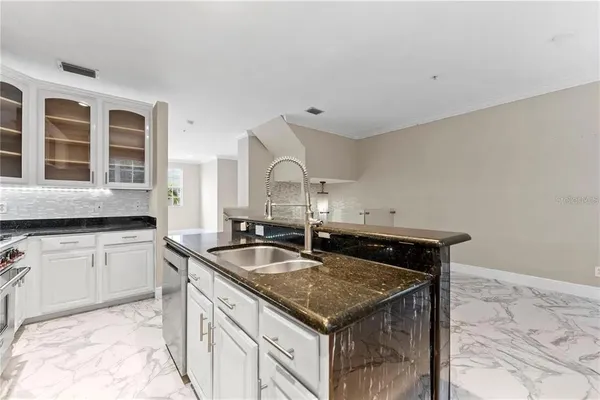 a kitchen with granite countertop a stove and a sink