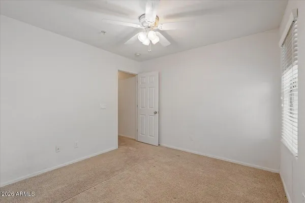 an empty room with windows and fan