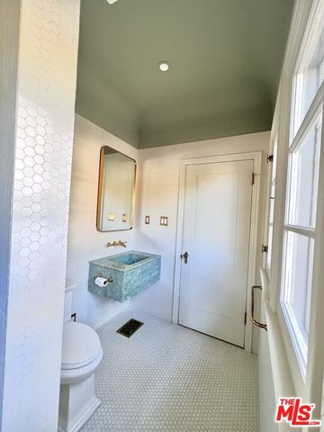 a bathroom with a granite countertop toilet a sink and a mirror