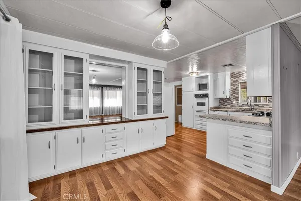 a kitchen with stainless steel appliances granite countertop a stove and a wooden floors