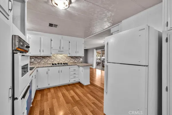a kitchen with granite countertop a sink a stove and cabinets