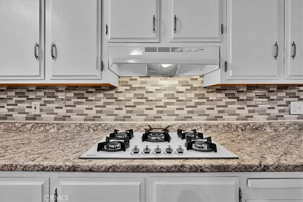 a kitchen with granite countertop cabinets appliances and a sink