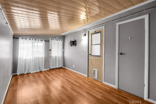 a view of empty room with wooden floor