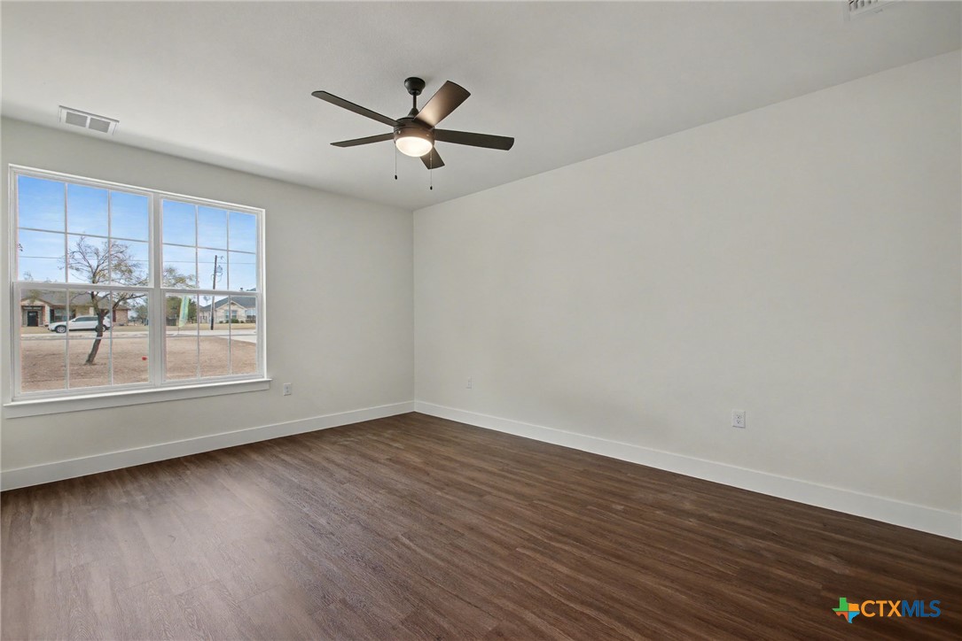 425 County Road 3152 Kempner, TX 76539 - Photo 14 of 27 an empty room with wooden floor fan and windows