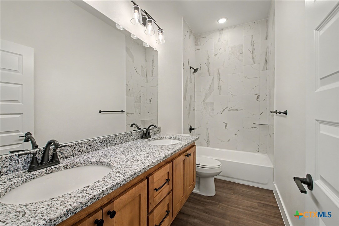 425 County Road 3152 Kempner, TX 76539 - Photo 20 of 27 a bathroom with a granite countertop sink a toilet and shower