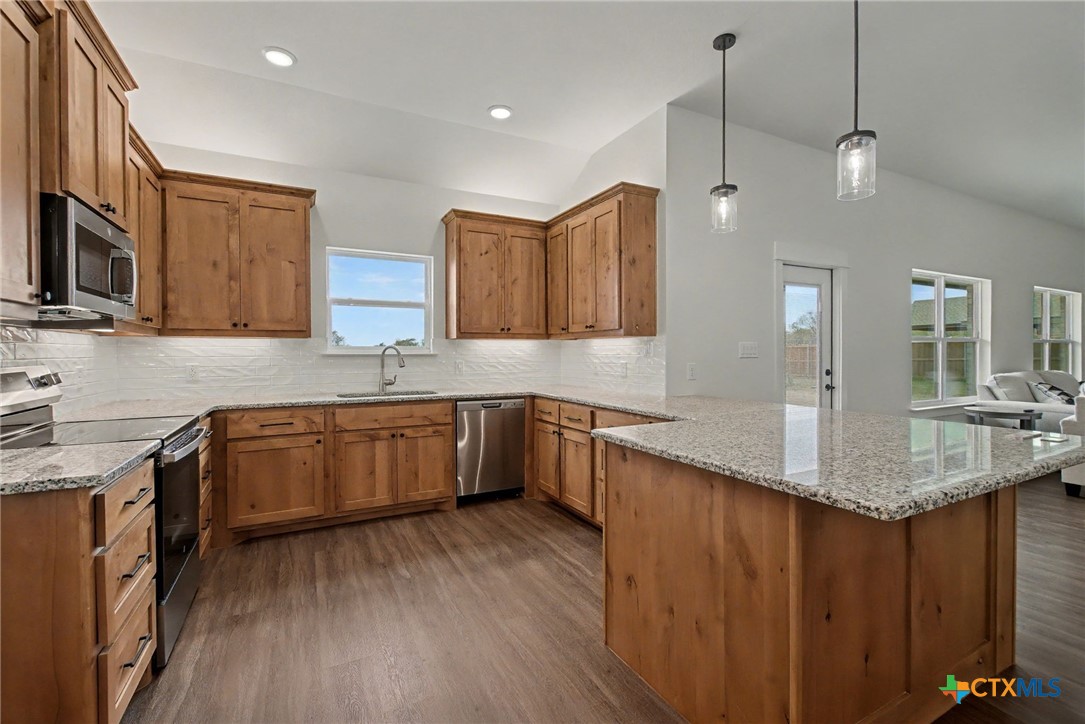 425 County Road 3152 Kempner, TX 76539 - Photo 9 of 27 a kitchen with granite countertop a sink cabinets and wooden floor