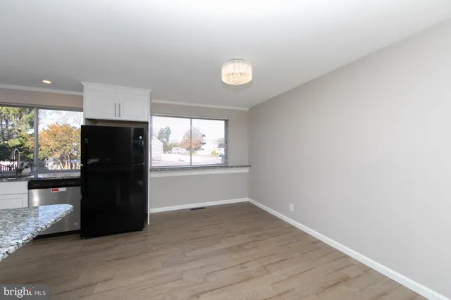an empty room with wooden floor and a window