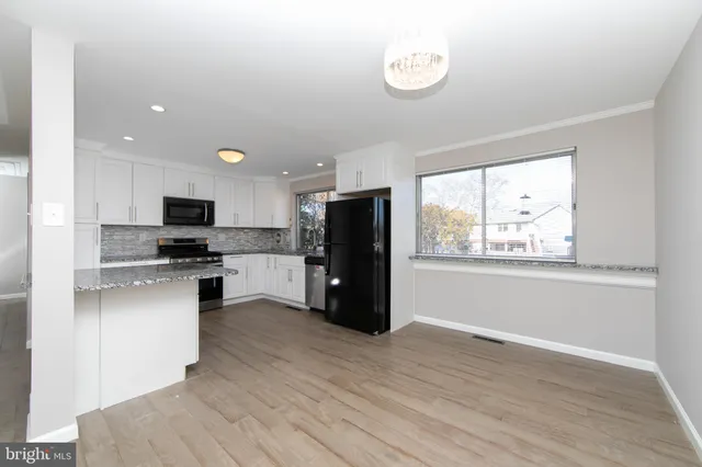 a kitchen with stainless steel appliances granite countertop a refrigerator and a stove top oven