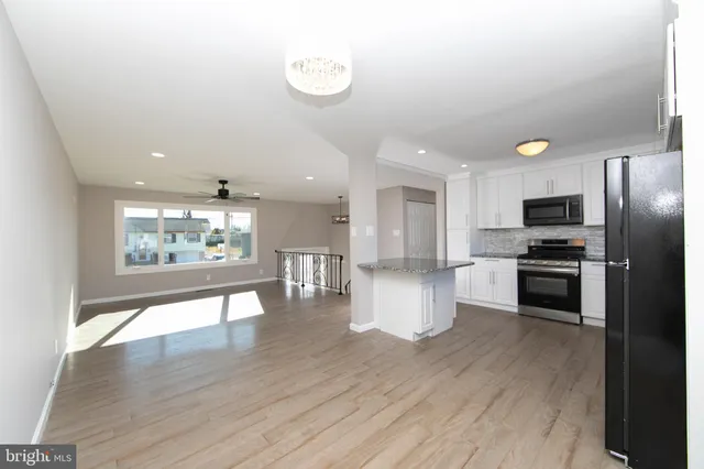 a open kitchen with white cabinets and stainless steel appliances