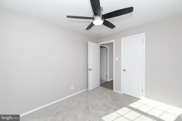 an empty room with a ceiling fan and a window