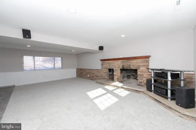 an empty room with windows and fireplace