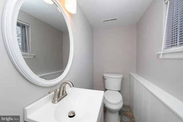 a bathroom with a toilet sink and mirror