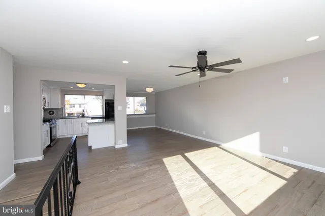 a living room with stainless steel appliances furniture and a view of kitchen