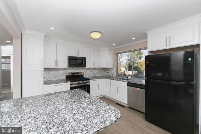 a kitchen with a refrigerator and a stove top oven