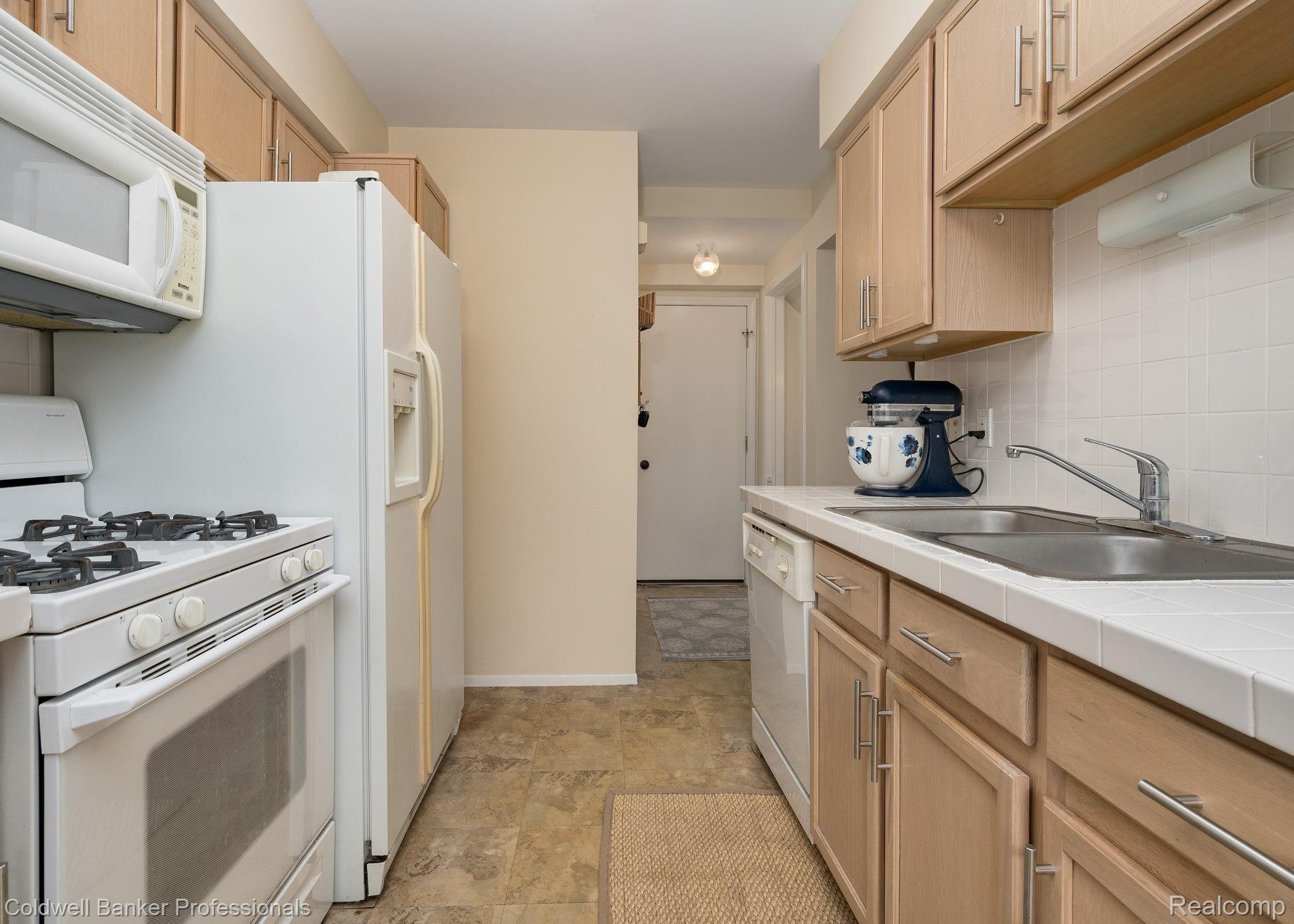 3048 High Pointe Ridge Road, Unit 47 Lake Orion, MI 48359 - Photo 11 of 21 Lots of cabinet space for this kitchen with direct access to garage