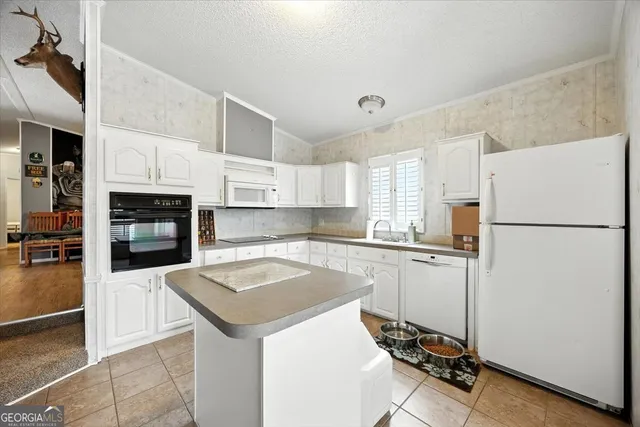 a view of a pool with lawn chairs and wooden fence