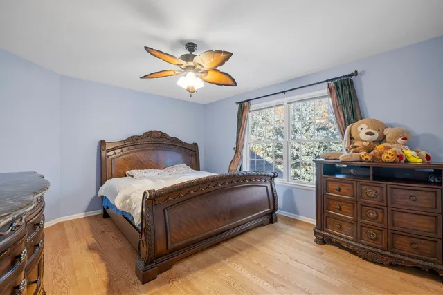 a bedroom with a bed and painting on the dresser