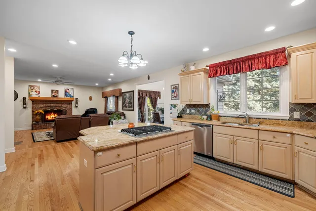a kitchen with kitchen island granite countertop a sink cabinets and window
