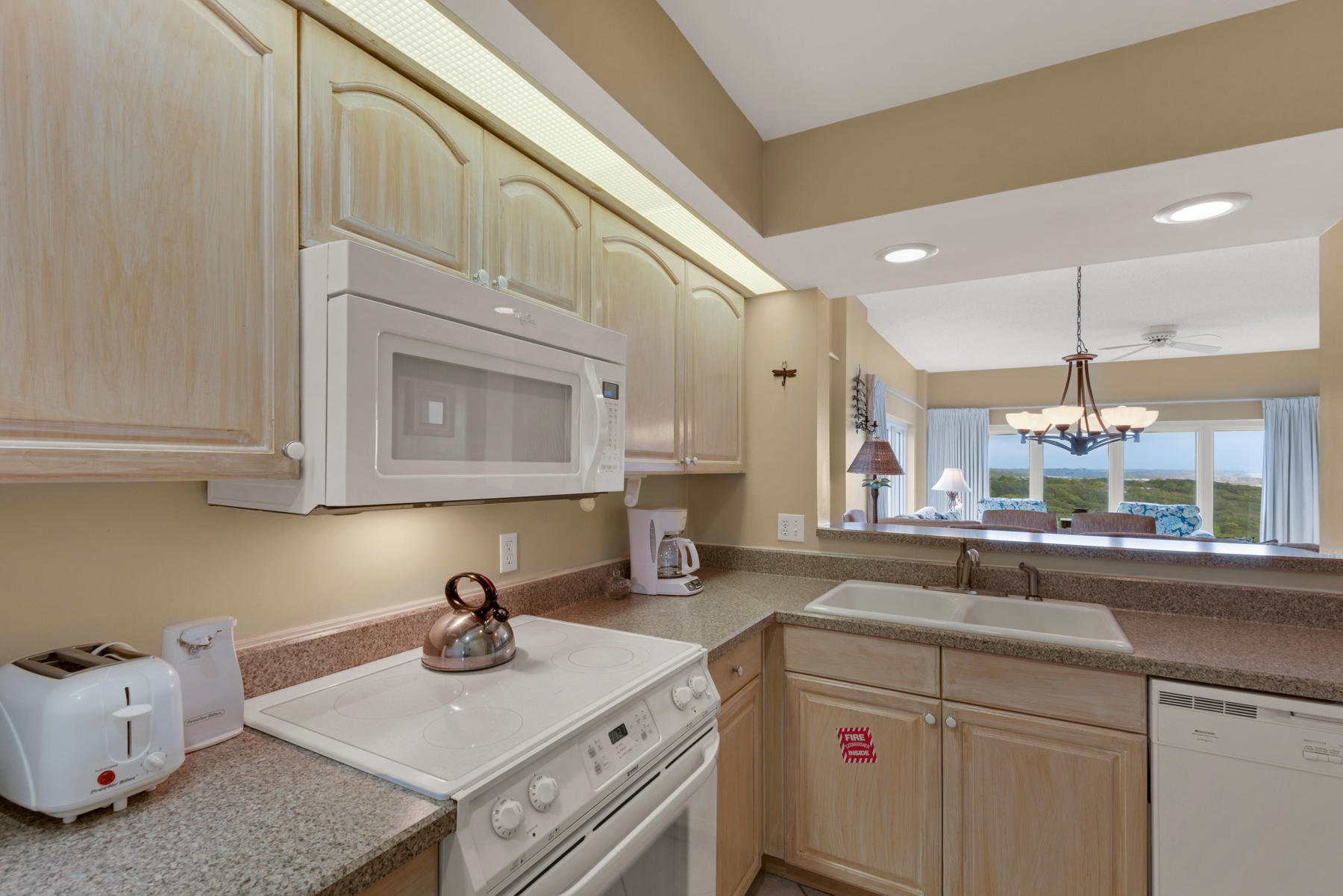 9011 Highway 98, Unit 701 Miramar Beach, FL 32550 - Photo 7 of 13 a kitchen with kitchen island granite countertop a sink a stove and cabinets