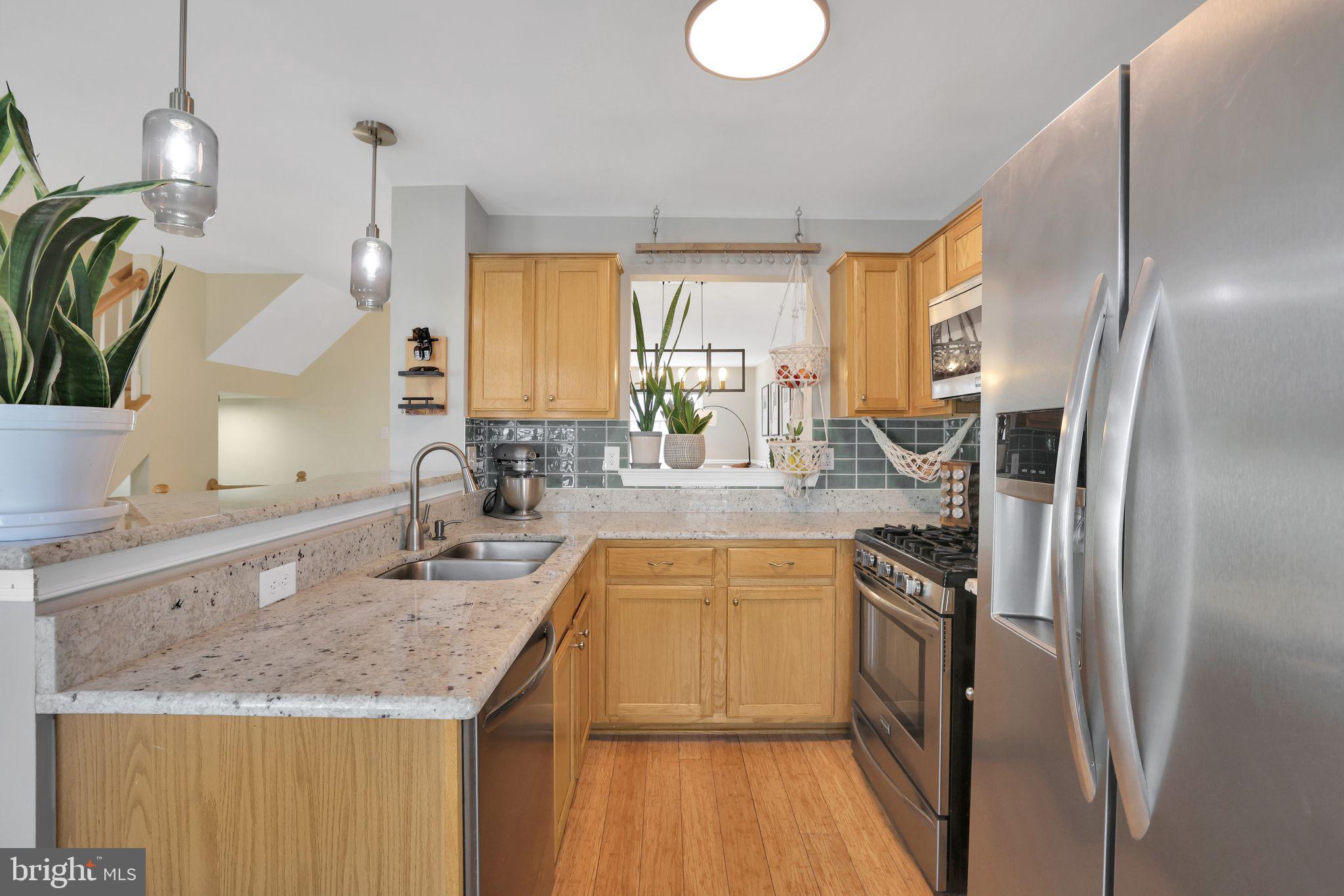 22952 Regent Terrace Sterling, VA 20166 - Photo 16 of 64 a kitchen with stainless steel appliances granite countertop a sink a stove and a refrigerator