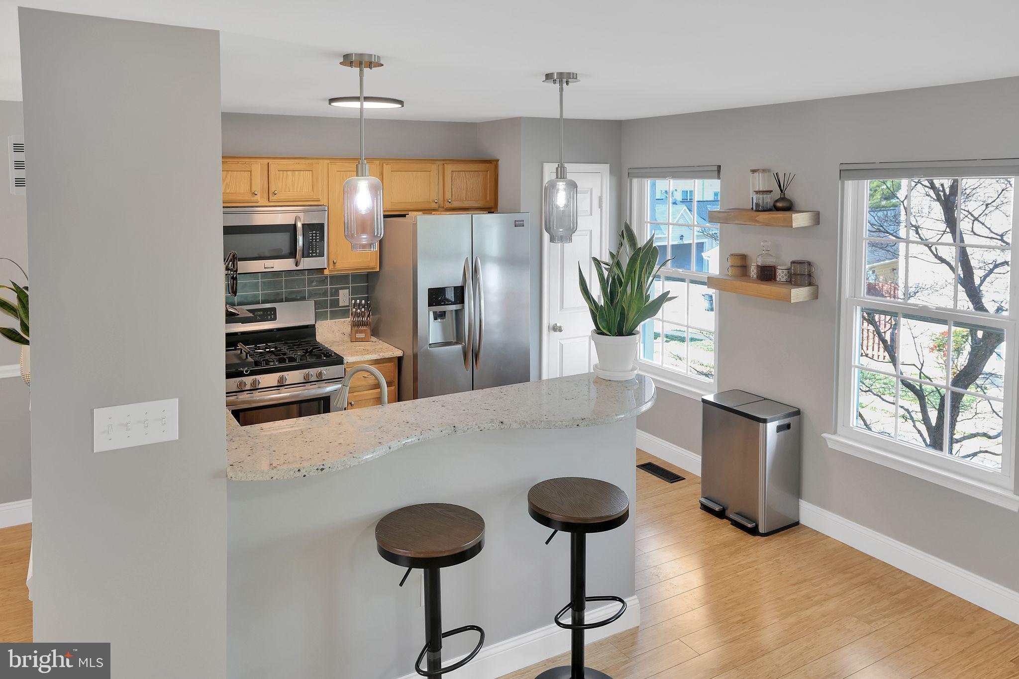 22952 Regent Terrace Sterling, VA 20166 - Photo 21 of 64 a kitchen with stainless steel appliances kitchen island a table and chairs in it