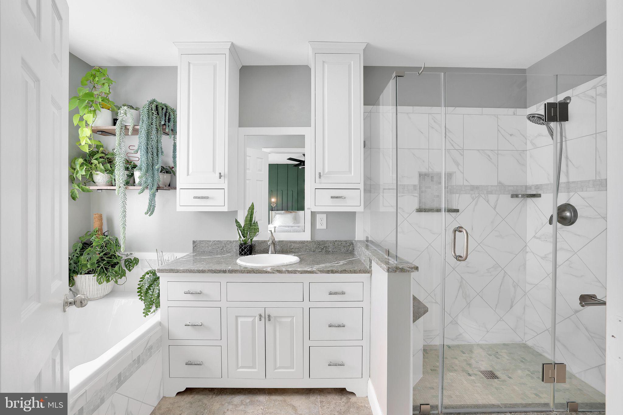 22952 Regent Terrace Sterling, VA 20166 - Photo 28 of 64 a bathroom with a granite countertop sink a mirror a glass door a shower and a mirror