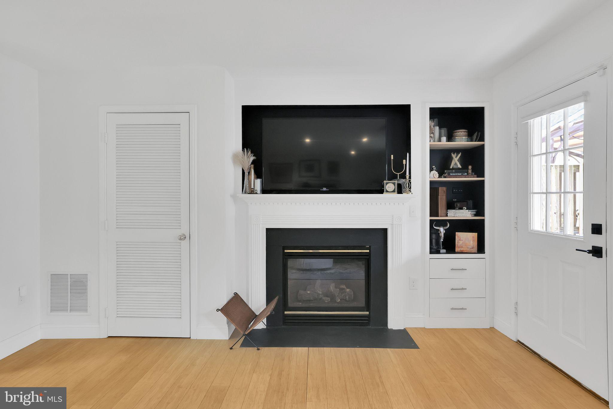 22952 Regent Terrace Sterling, VA 20166 - Photo 47 of 64 a living room with a fireplace and a flat screen tv