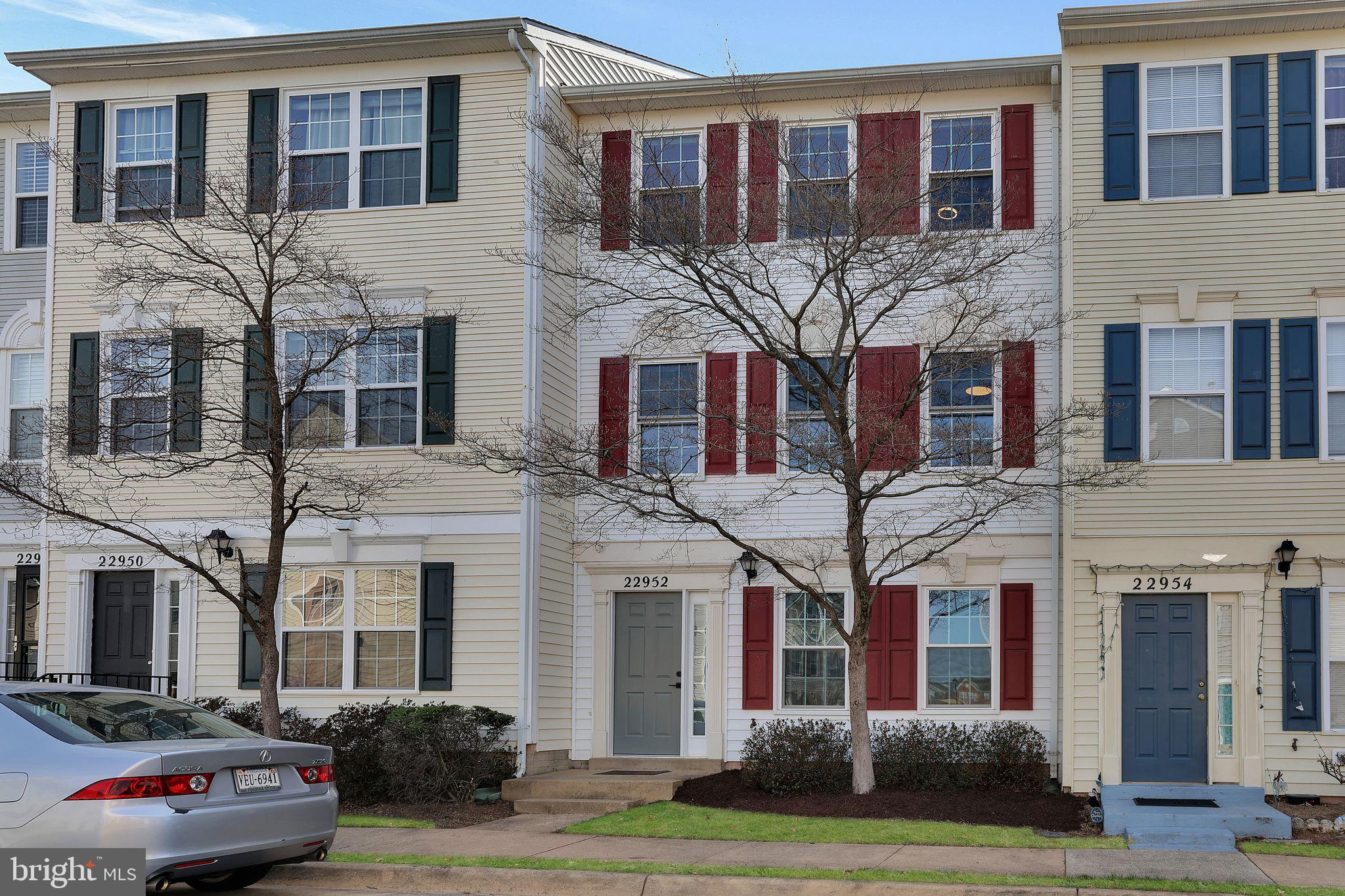 22952 Regent Terrace Sterling, VA 20166 - Photo 59 of 64 a front view of a residential apartment building with a yard and entryway