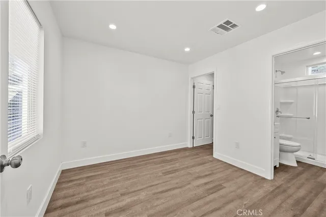 an empty room with wooden floor and a window