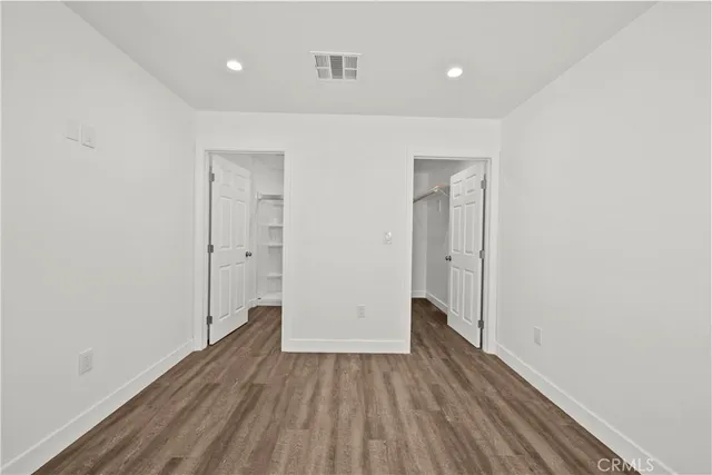 a view of a room with wooden floor and a ceiling fan